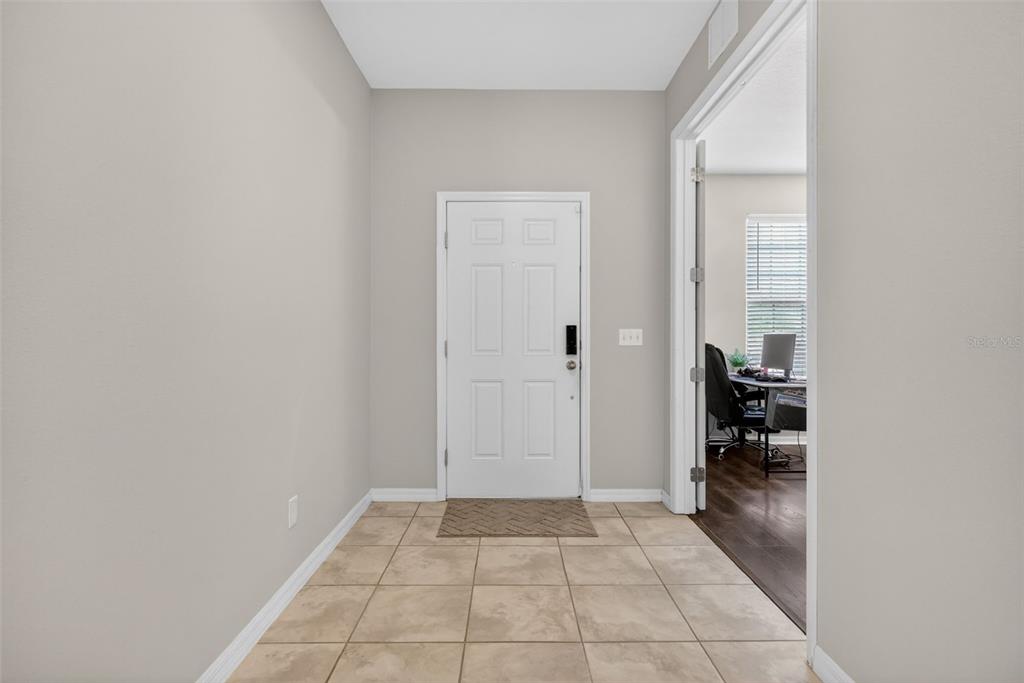 A tiled entryway features a white front door and an open doorway to an office — 30115 CHEVAL STREET, MOUNT DORA, FL