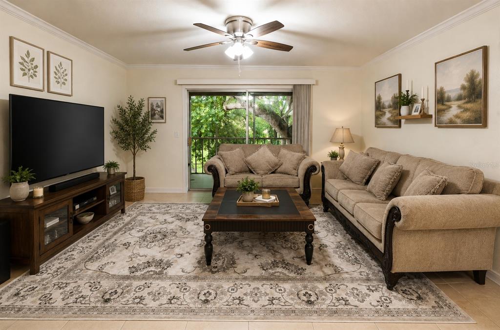 A living room features a beige sofa and loveseat, a coffee table, and a television — 2305 HAYWOOD COURT UNIT 203, MAITLAND, FL