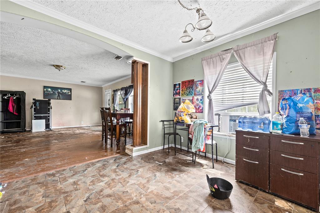 An open-concept dining and living area features tile flooring, wood trim, and a window — 13573 98TH STREET, LIVE OAK, FL