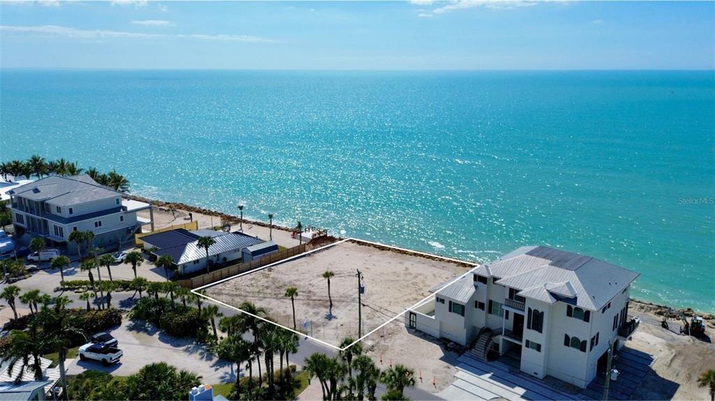 An aerial view shows a vacant, rectangular waterfront lot situated between two large houses — 3761 CASEY KEY ROAD, NOKOMIS, FL