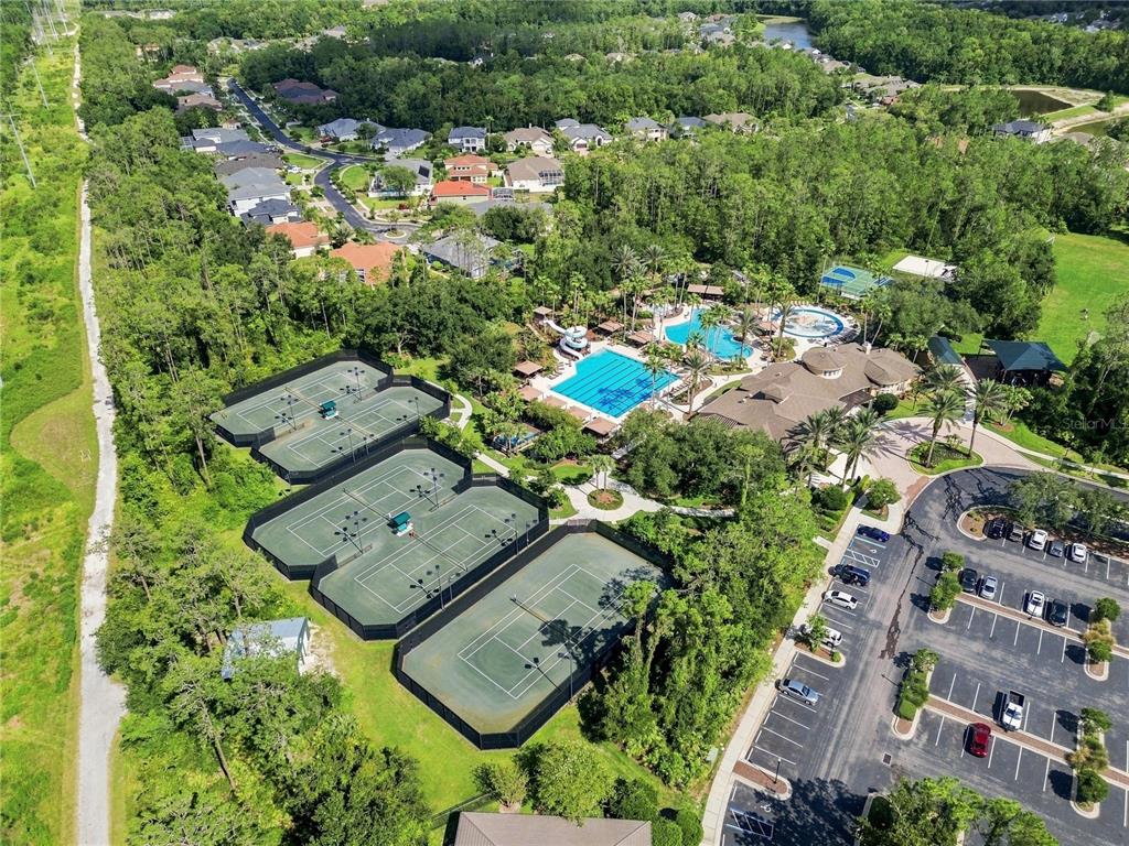 An aerial view shows tennis courts, a swimming pool complex, and a parking lot — 2340 SPRING HOLLOW LOOP, WESLEY CHAPEL, FL