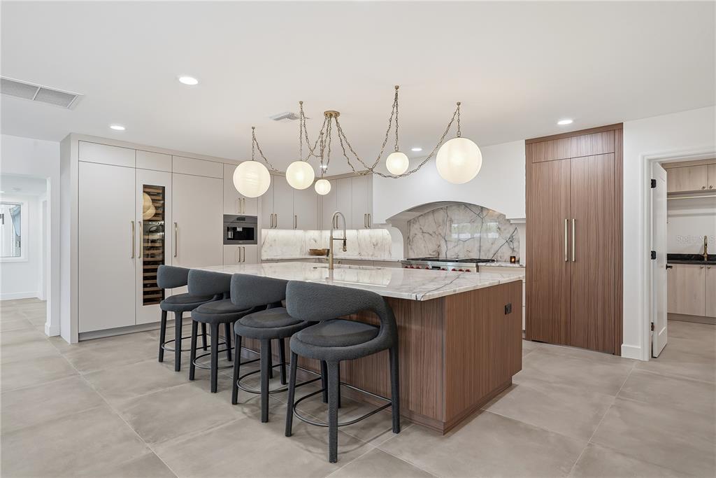 A backyard features a swimming pool, a covered patio with seating, and an outdoor kitchen — 3896 42ND AVENUE S, ST PETERSBURG, FL