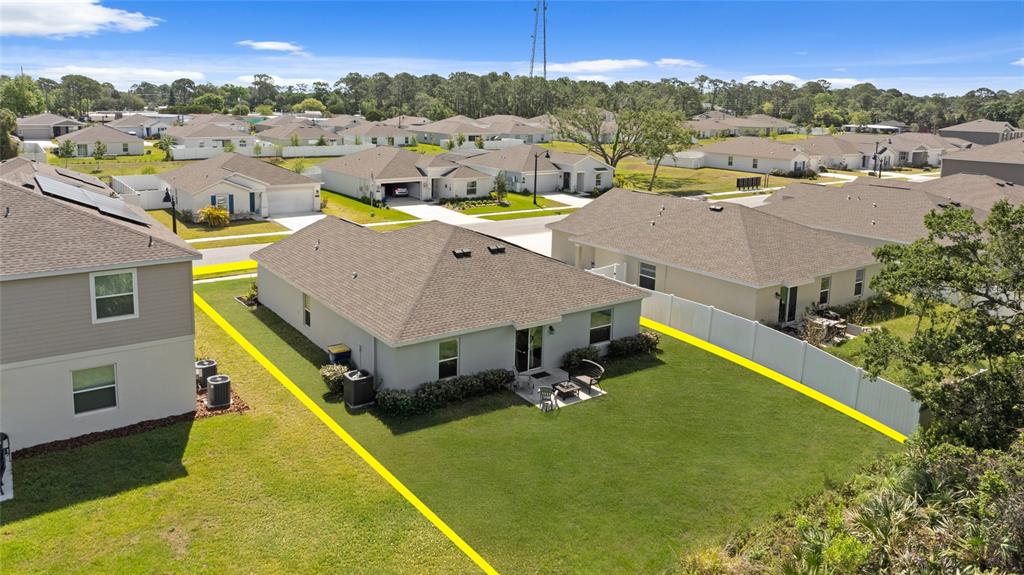 An aerial view shows a suburban house with a fenced backyard and a patio — 2518 HOPTREE LANE, EDGEWATER, FL