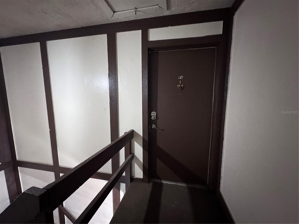 A brown door with a knocker and keypad lock is situated at the top of stairs — 5343 HANSEL AVENUE UNIT F4, ORLANDO, FL