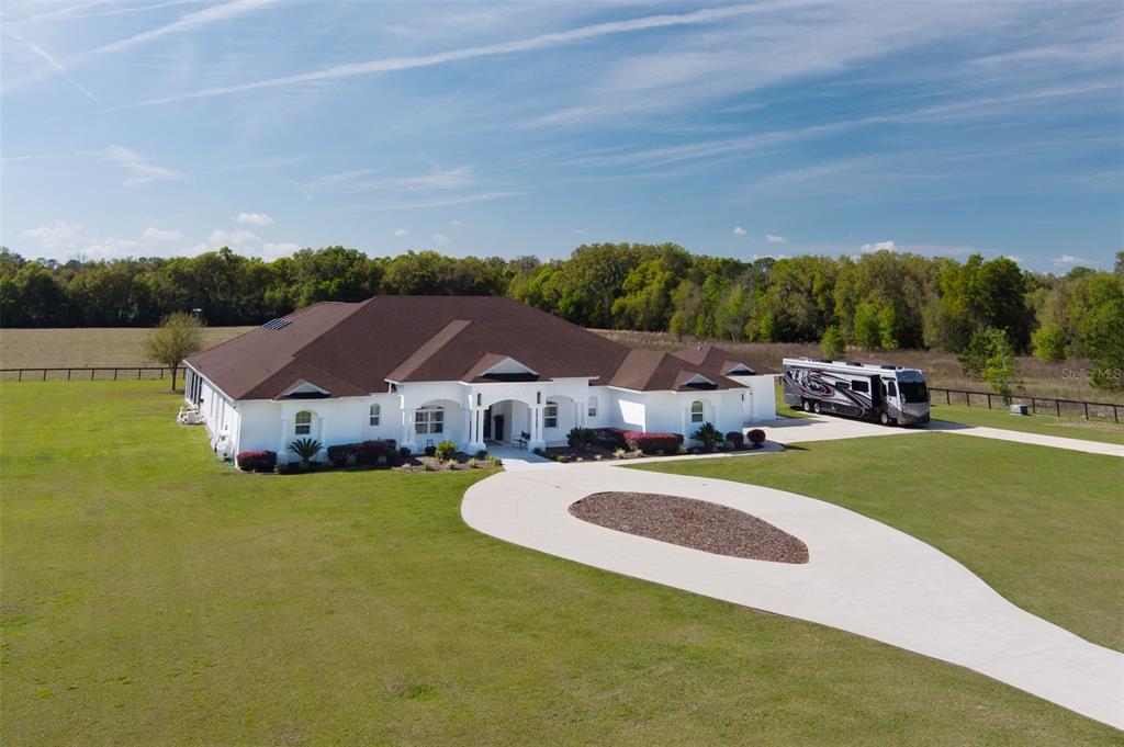 An aerial view of a white single-story house with a brown roof and a driveway — 6160 W HIGHWAY 326, OCALA, FL