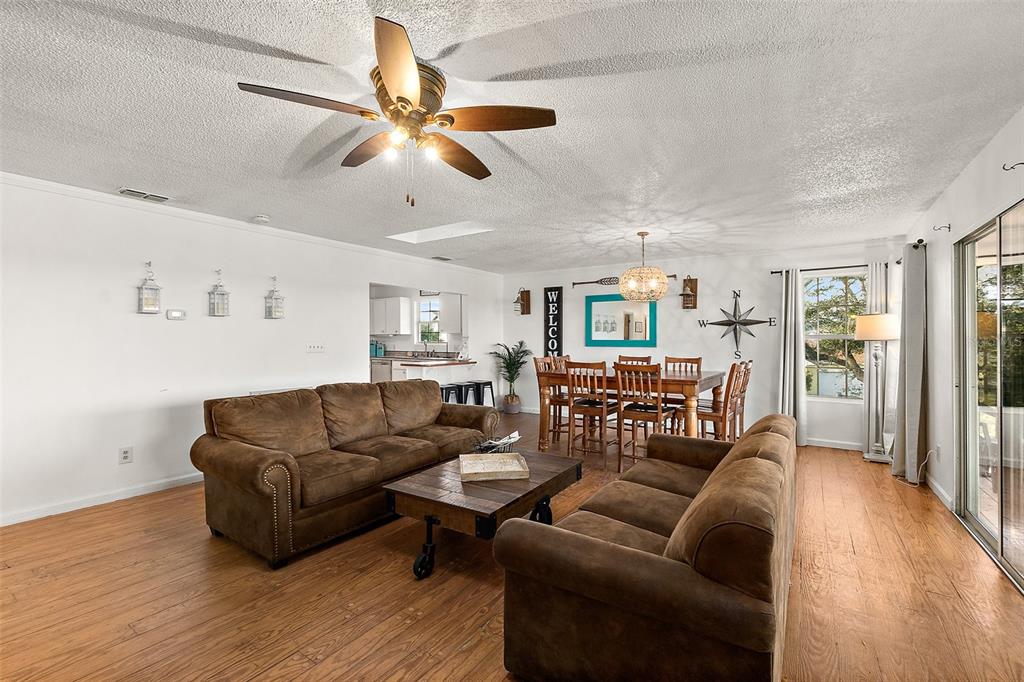 A living room with brown sofas, a wooden coffee table, and an adjacent dining area — 32 ARMAND BEACH DRIVE, PALM COAST, FL