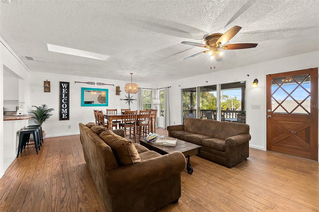 A living room with brown sofas, a wooden coffee table, and a dining area — 32 ARMAND BEACH DRIVE, PALM COAST, FL