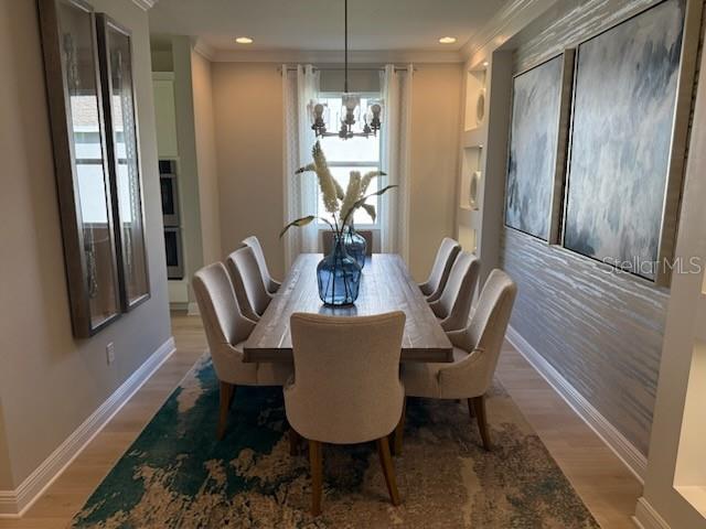 A dining room features a wooden table, upholstered chairs, a chandelier, and large wall art — 5288 OBSIDIAN GATE DRIVE, MOUNT DORA, FL