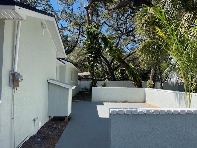 A view of a light-colored house exterior with a small shed and a concrete patio — 741 28TH AVENUE S, ST PETERSBURG, FL