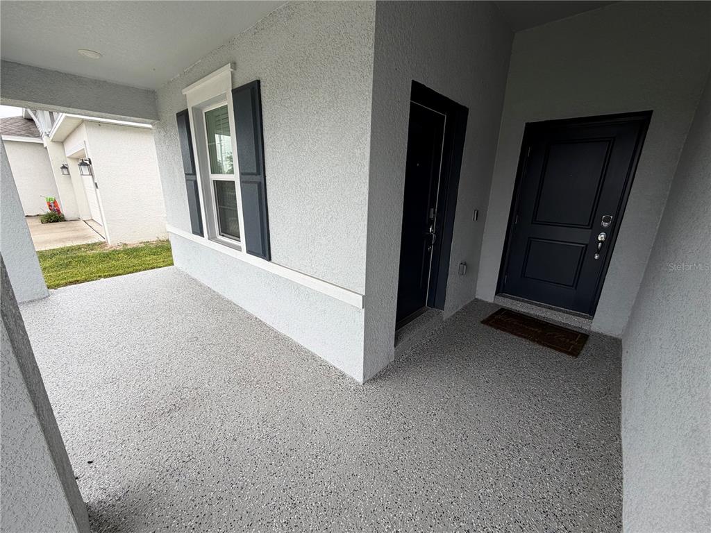 A tiled entryway features a white front door, a shoe rack, and framed wall art — 225 LAWSON AVENUE, HAINES CITY, FL