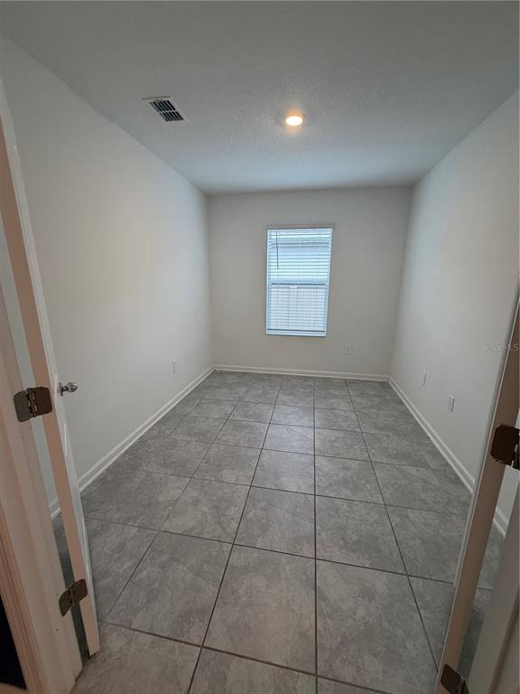 A living room with a dark blue accent wall, gray furniture, and an open kitchen — 225 LAWSON AVENUE, HAINES CITY, FL