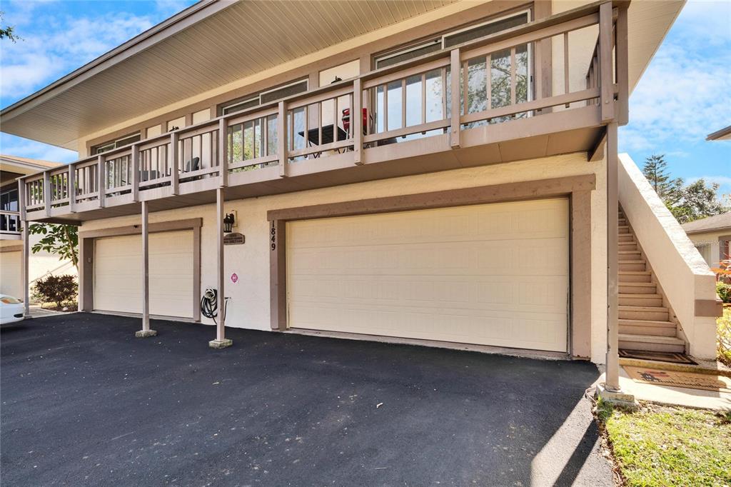A two-story building features a double garage, a balcony, and an exterior staircase — 1849 BOUGH AVENUE UNIT D, CLEARWATER, FL