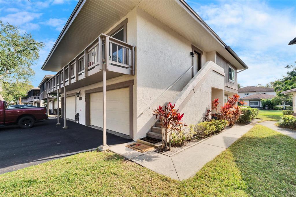 A two-story building with a balcony, garage doors, and an exterior staircase — 1849 BOUGH AVENUE UNIT D, CLEARWATER, FL