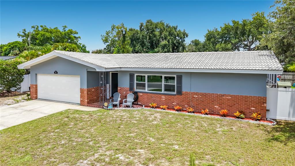A single-story house with a gray exterior, brick base, white roof, and a two-car garage — 2198 ACADEMY DRIVE, CLEARWATER, FL