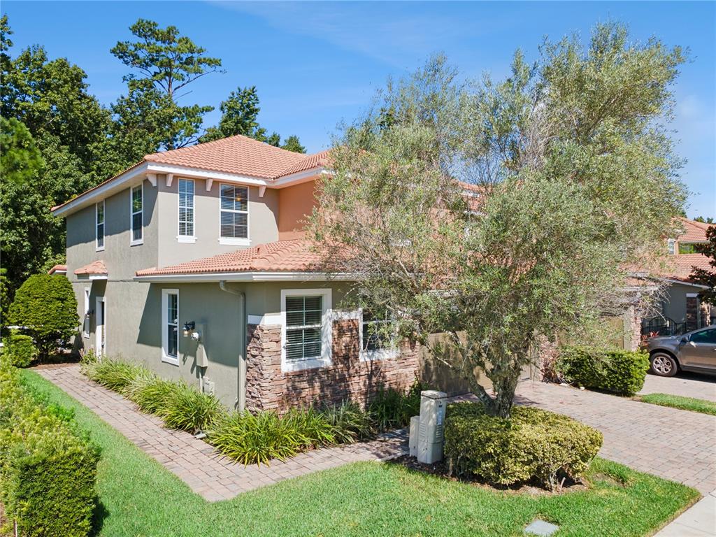 A two-story house with a tiled roof, stone accents, and a paved driveway — 624 VENICE PLACE, SANFORD, FL