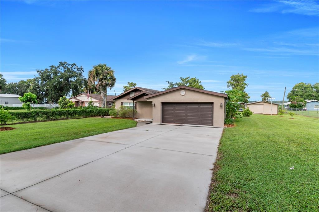 A single-story house with a brown garage door and a concrete driveway — 9431 LAKE MARION CREEK ROAD, HAINES CITY, FL