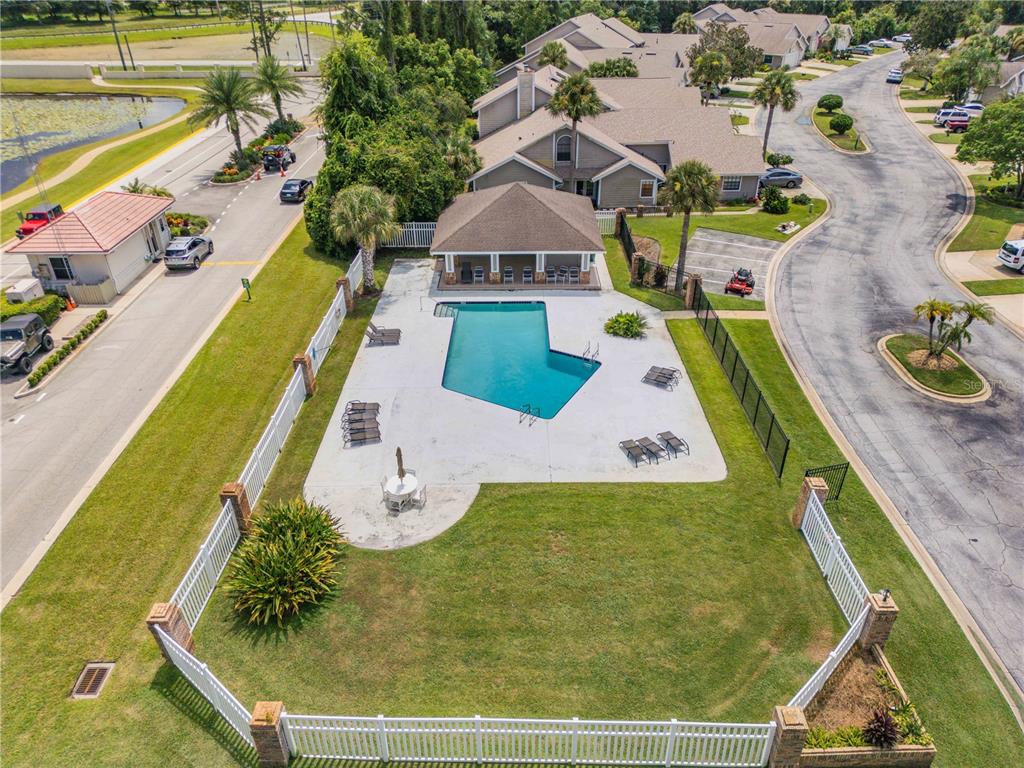 An aerial view shows a community swimming pool with a deck, pavilion, and surrounding lawn — 2016 CORNELL PLACE, PORT ORANGE, FL