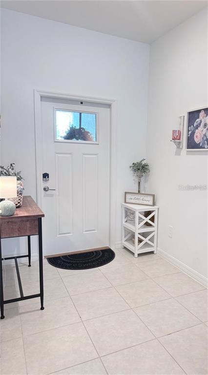 An entryway features a white front door, tiled floors, and a small white side table — 6199 SHINER STREET, LAND O LAKES, FL