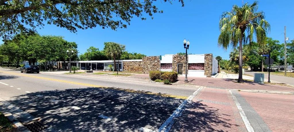 A single-story commercial building with a stone facade sits along a street with palm trees — 421 E KENNEDY BOULEVARD, MAITLAND, FL