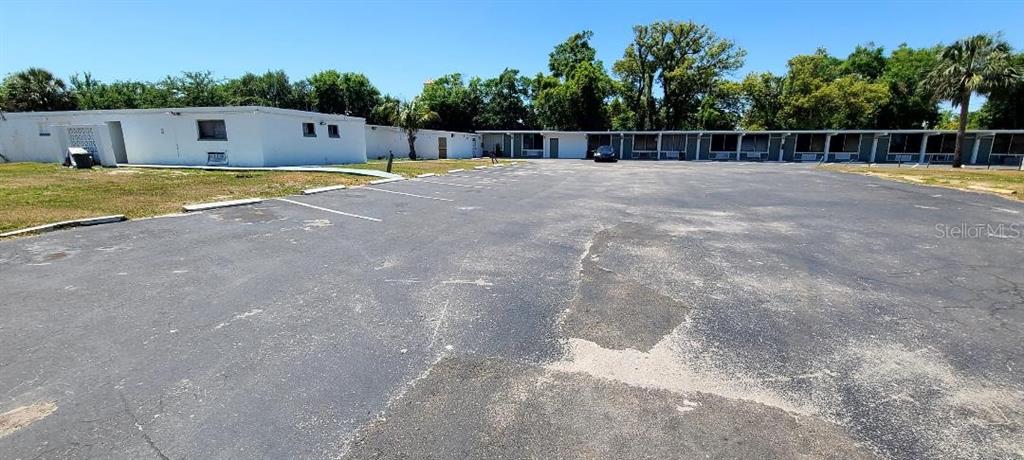 A large, paved parking lot sits in front of a long, single-story motel building — 421 E KENNEDY BOULEVARD, MAITLAND, FL