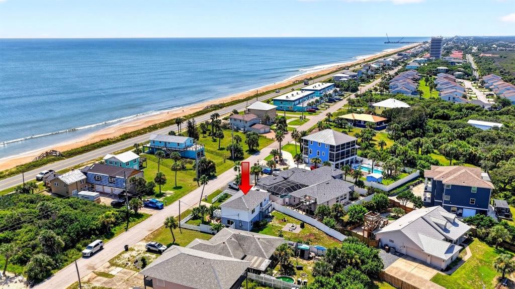 An aerial view shows a coastal neighborhood with a red arrow pointing to a house — 1901 N CENTRAL AVENUE, FLAGLER BEACH, FL