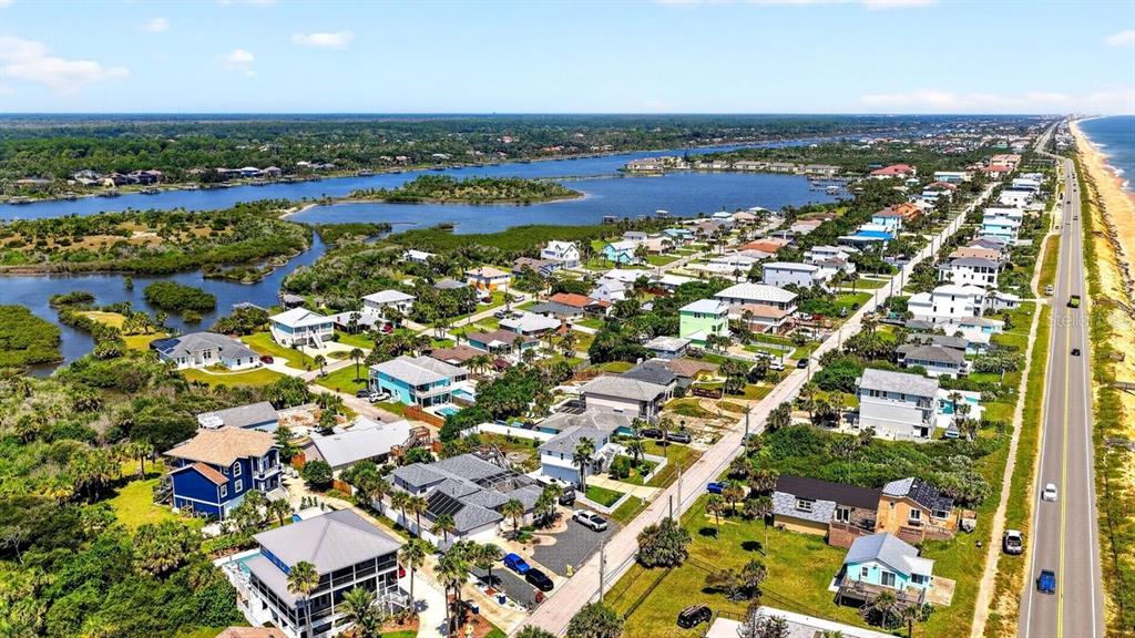 An aerial view shows a coastal neighborhood with houses situated between a waterway and a road — 1901 N CENTRAL AVENUE, FLAGLER BEACH, FL