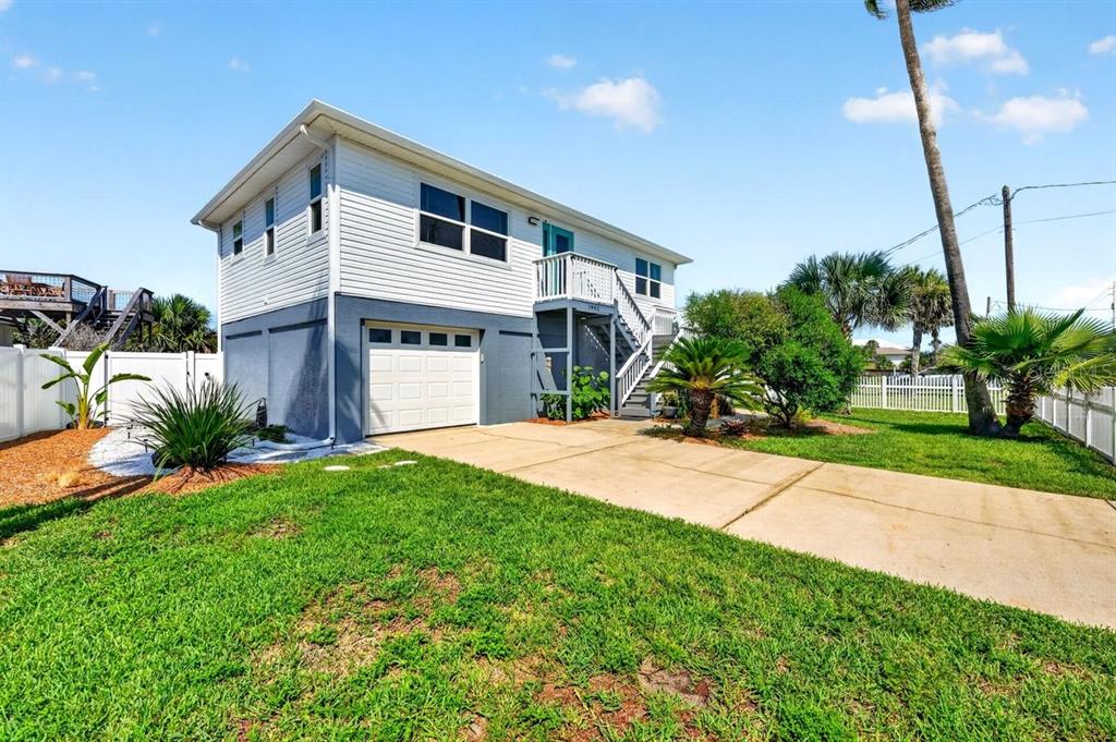 A two-story house with white siding, a gray base, a garage, and an exterior staircase — 1901 N CENTRAL AVENUE, FLAGLER BEACH, FL
