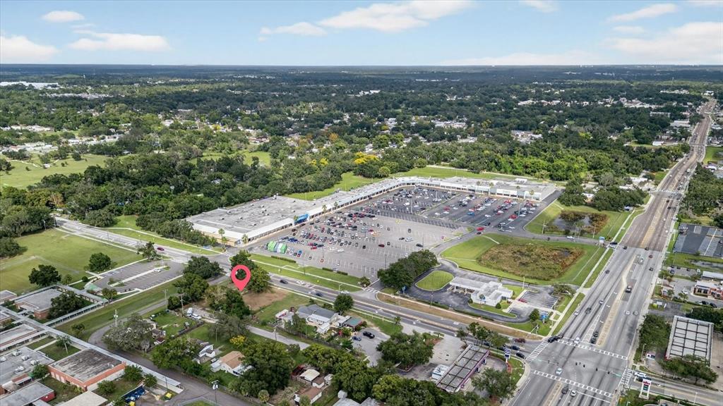 This aerial view shows a vacant lot marked with a pin near a shopping center — 4020 579 HIGHWAY, SEFFNER, FL