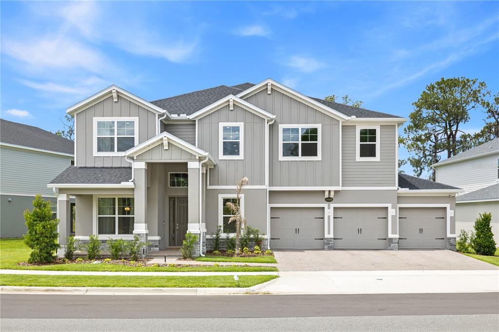 A two-story house with gray siding, a three-car garage, and a covered front entryway — 17372 GLOSSY POMELO WAY, WINTER GARDEN, FL