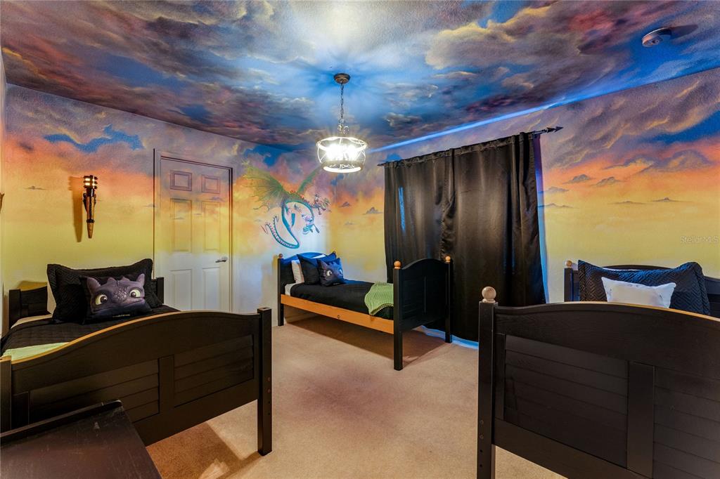 A bedroom features three twin beds, a dragon mural, and a painted sky ceiling — 2623 PAWNALL STREET, KISSIMMEE, FL