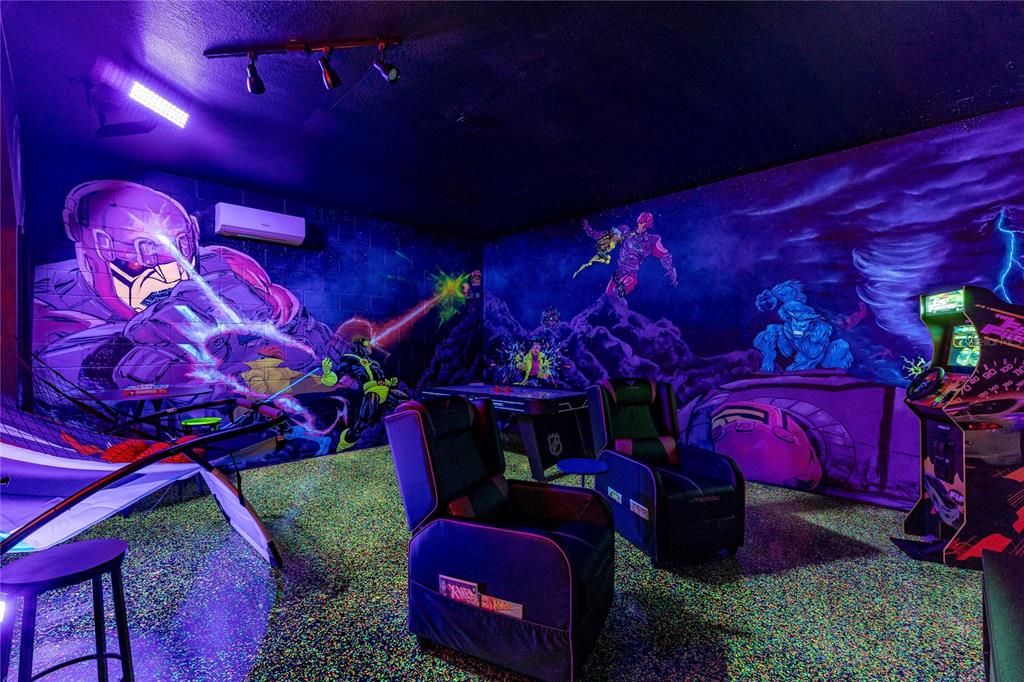 A game room features blacklight-reactive Marvel superhero murals, neon lighting, gaming chairs, and arcade machines — 2623 PAWNALL STREET, KISSIMMEE, FL
