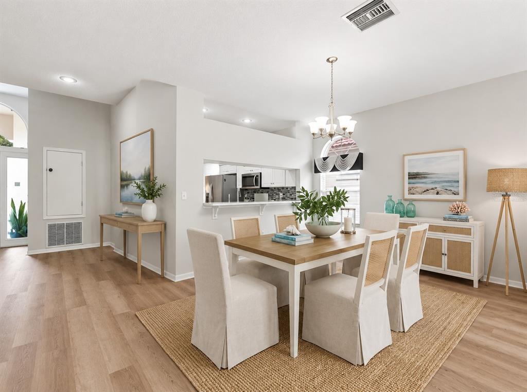 An empty room with hardwood floors and a large sliding glass door leading to a patio — 1333 LINDENWOOD DRIVE, TARPON SPRINGS, FL