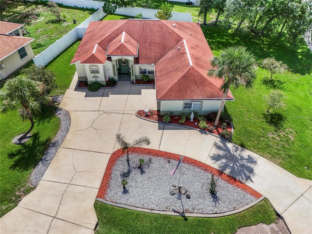 An aerial view shows a single-story house with a red roof, concrete driveway, and landscaping — 43 FOLSON LANE, PALM COAST, FL