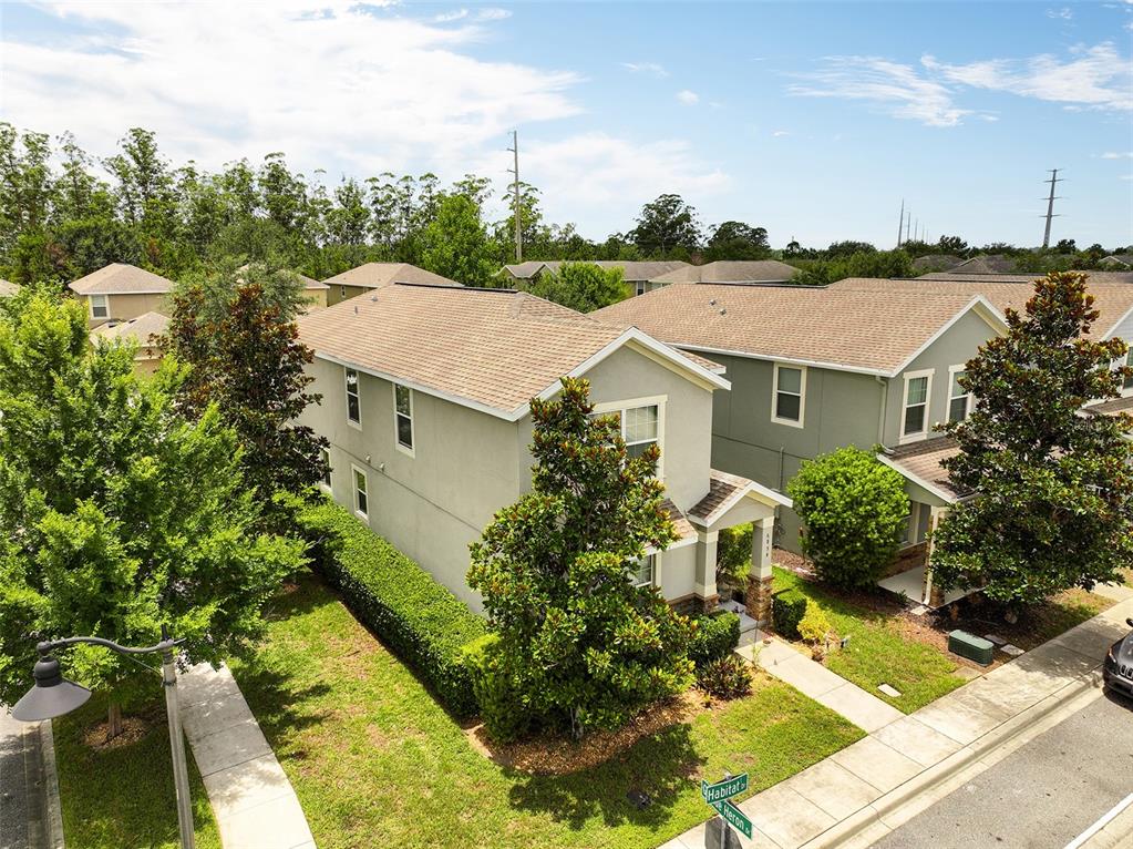 An open-concept kitchen with dark cabinets and a breakfast bar overlooks a tiled living area — 6834 HABITAT DRIVE, HARMONY, FL