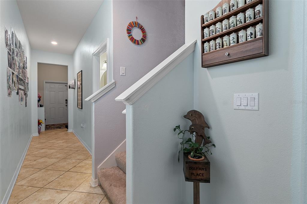 A kitchen features dark wood cabinets, stainless steel appliances, a granite island, and two chairs — 6834 HABITAT DRIVE, HARMONY, FL