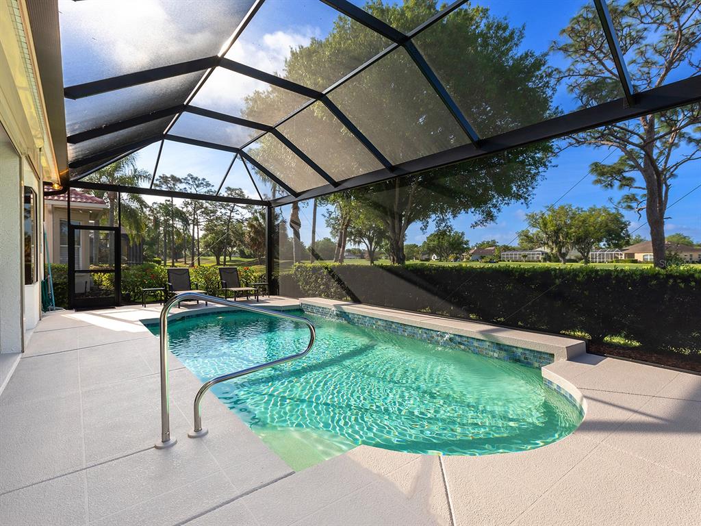 A screened-in patio features a small swimming pool with a metal handrail and tiled accents — 10106 GLENMORE AVENUE, BRADENTON, FL