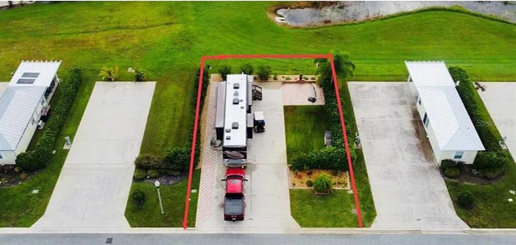 An aerial view shows a recreational vehicle parked on a concrete pad between two structures — 9531 SE 47TH WAY UNIT 280, WEBSTER, FL
