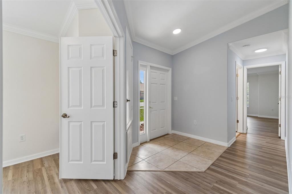 An entryway with tile flooring, light gray walls, and wood-look laminate flooring in adjacent rooms — 18630 ROLLING HILLS LOOP, HUDSON, FL
