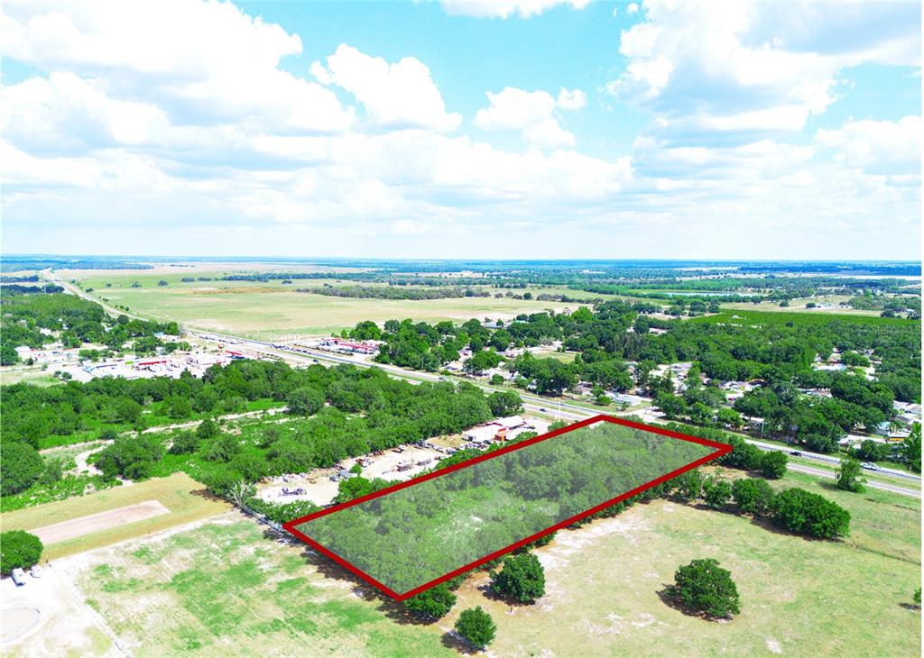 An aerial view shows a rectangular plot of land outlined in red near a highway — SR-60, BARTOW, FL