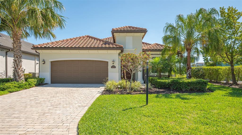 A single-story house with a tiled roof, a paved driveway, and a two-car garage — 6137 CESSNA RUN, BRADENTON, FL