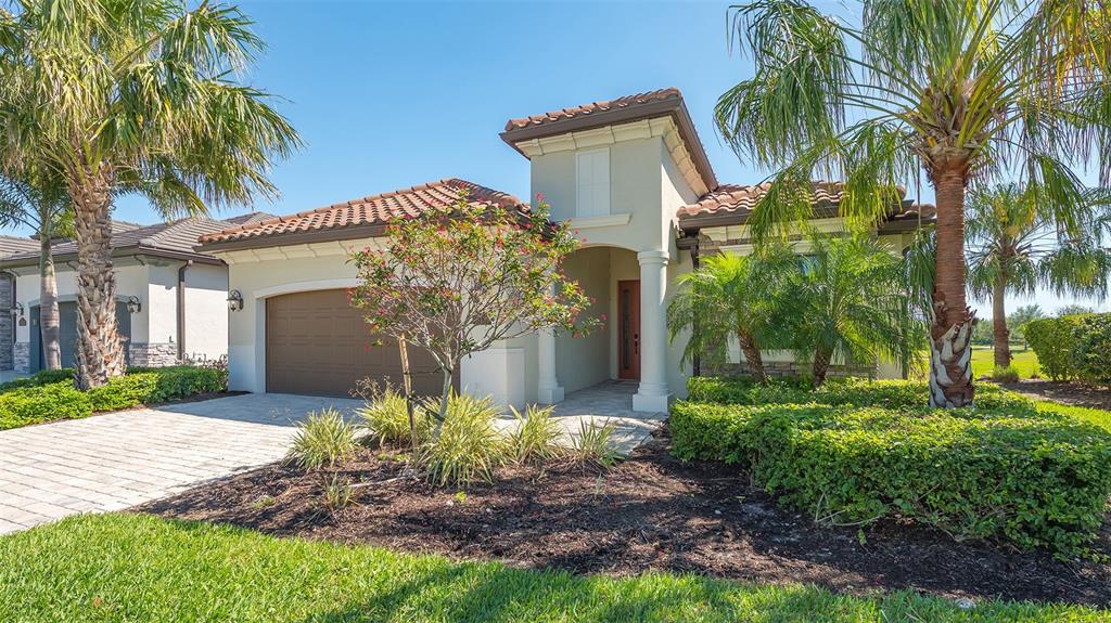 A single-story house with a brown garage door, a tiled roof, and landscaped front yard — 6137 CESSNA RUN, BRADENTON, FL