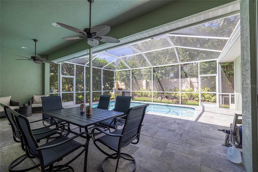 A covered patio with a dining set overlooks a screened-in swimming pool and backyard — 3009 KEY HARBOR DRIVE, SAFETY HARBOR, FL