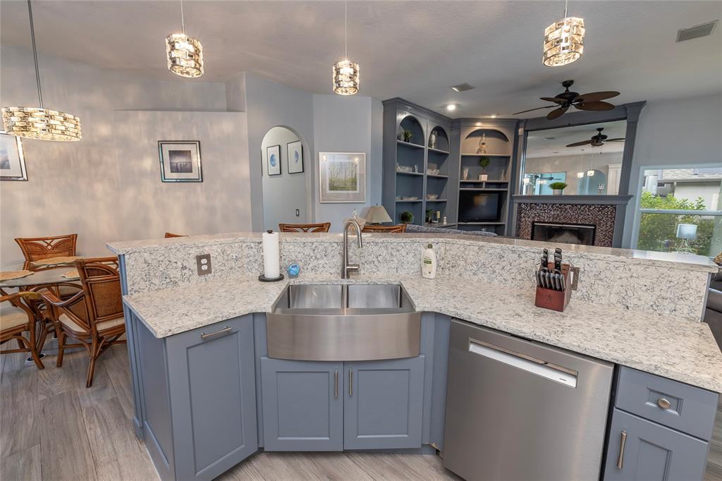 A kitchen island with a farmhouse sink, granite countertops, and blue cabinets faces a living area — 3009 KEY HARBOR DRIVE, SAFETY HARBOR, FL