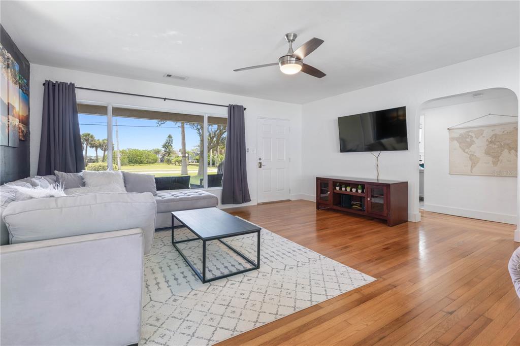 A living room features a sectional sofa, a coffee table, a television, and hardwood floors — 504 RIVERSIDE DRIVE, HOLLY HILL, FL