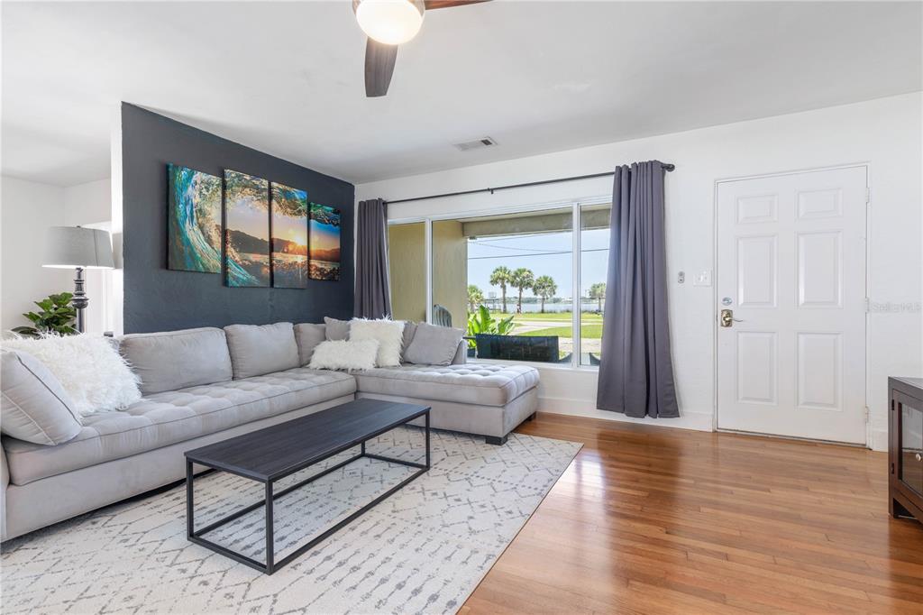A living room features a grey sectional sofa, a coffee table, and a view of water — 504 RIVERSIDE DRIVE, HOLLY HILL, FL