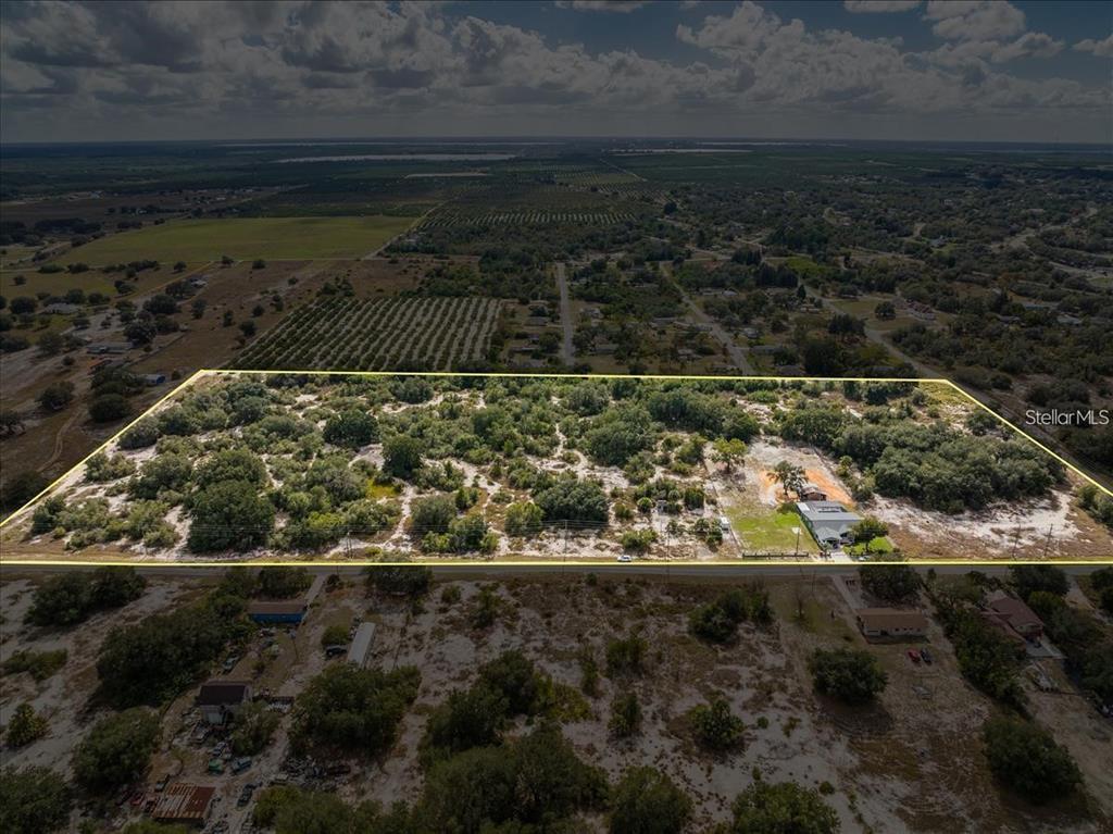 An aerial view shows a large, rectangular plot of land with sparse vegetation and a house — LIBBY RD, BABSON PARK, FL