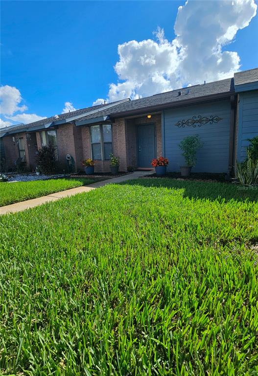 A single-story brick and blue siding house with a front lawn under a cloudy sky — 2510 KING OAK CIRCLE, ST CLOUD, FL