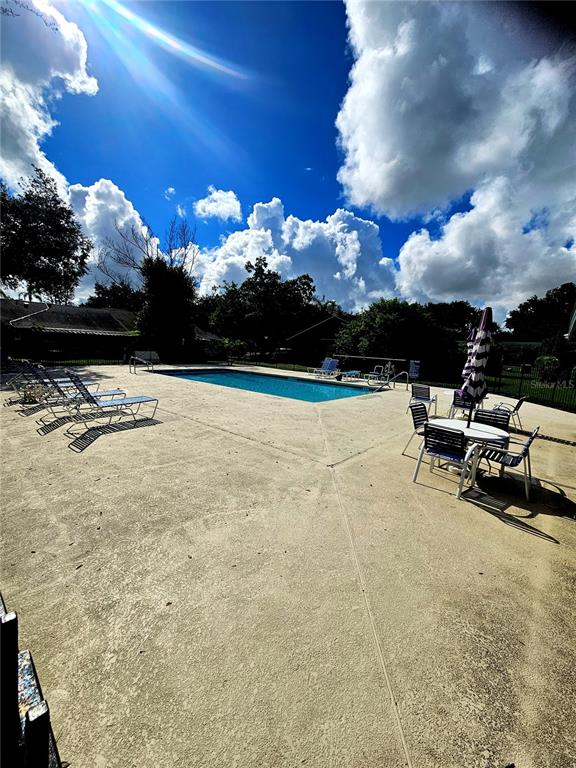An outdoor swimming pool surrounded by a concrete deck with lounge chairs and tables — 2510 KING OAK CIRCLE, ST CLOUD, FL