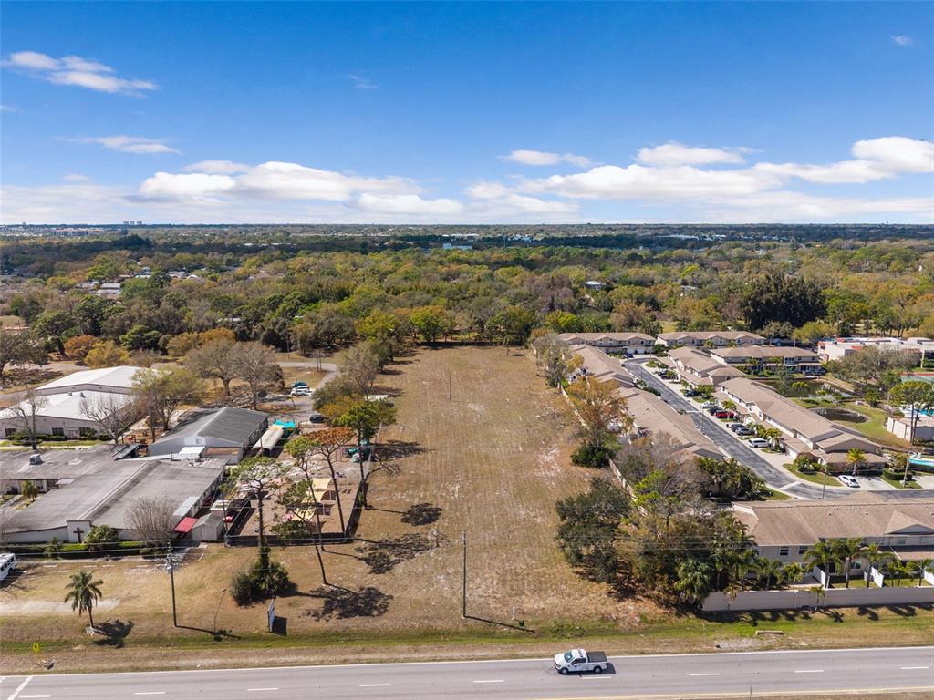 An aerial view shows a vacant rectangular lot situated between a commercial building and townhomes — 9530 STARKEY ROAD, SEMINOLE, FL