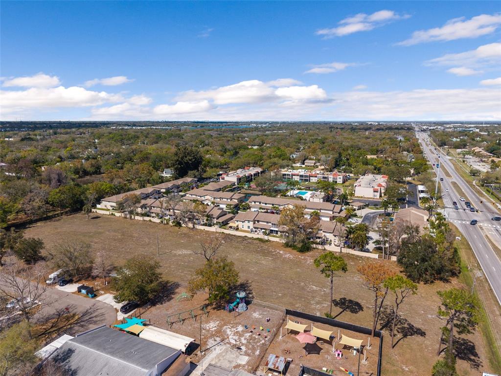 An aerial view shows a residential complex, a large vacant lot, and a nearby highway — 9530 STARKEY ROAD, SEMINOLE, FL